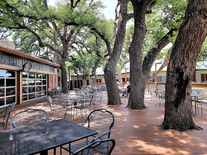 Rustic Outdoor Dahlia Cafe Patio with Large Oak Trees Daytime view of a Dahlia Cafe outdoor deck and patio seating shaded by large, mature oak trees.
